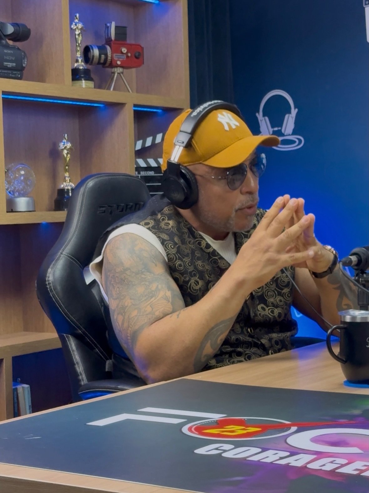Jaime Marcelo no Focus 23 Coragem, usando fones e boné amarelo durante o podcast